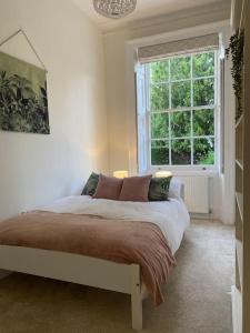 a bedroom with a bed with a large window at Regency Apartment in Leamington Spa