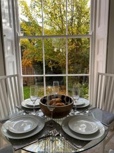 a table with a bowl of food and glasses on it at Regency Apartment in Leamington Spa