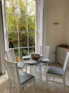 a dining room with a table and chairs and a window at Regency Apartment in Leamington Spa