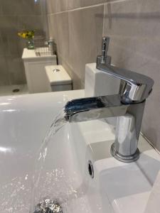 a bathroom sink with water running from a faucet at Regency Apartment in Leamington Spa