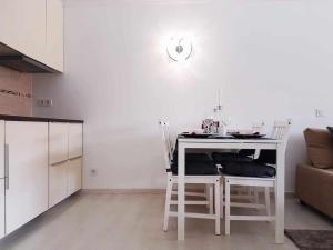 een keuken met een tafel en stoelen in een kamer bij Lujoso apartamento en de la isla de puerto Marina in Benalmádena