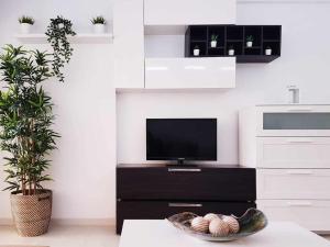 een woonkamer met een tv en een tafel bij Lujoso apartamento en de la isla de puerto Marina in Benalmádena