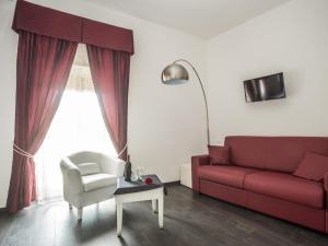 ローマにあるロイヤル ルームズのリビングルーム(赤いソファ、椅子付)