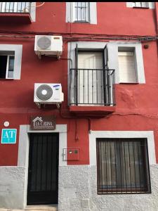 a red building with two windows and a balcony at La Casina Apartamento Turistico centro Plasencia AT-CC-0650 in Plasencia