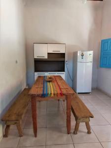 クムルサティバにあるCasa Passarinhosのキッチン(木製テーブル、冷蔵庫付)