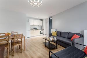 a living room with a blue couch and a table at Chill Apartments Marywilska in Warsaw