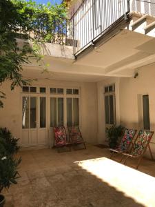 - un ensemble de chaises assises sur une terrasse dans l'établissement Maison Boussingault, à Avignon