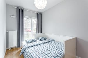 una camera bianca con un letto e una finestra di Chill Apartments Marywilska II a Varsavia