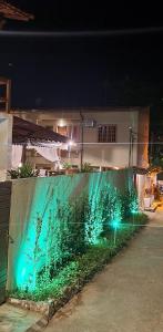 a fence with green lights in front of a building at Pousada Sakura Rio Mar in Abraão