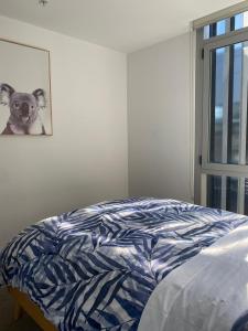 a bed in a bedroom with a picture of a dog at Bayside Melbourne Apartment in Melbourne