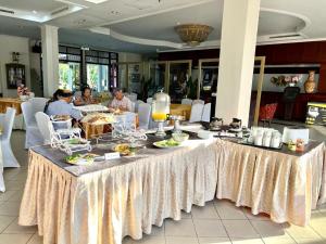 una mesa larga con comida en un restaurante en THE CLOVE MONT HOTEL, en Kampung Gurun