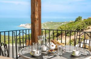 a table with a view of the ocean on a balcony at Punta Falcone Resort in Santa Teresa Gallura