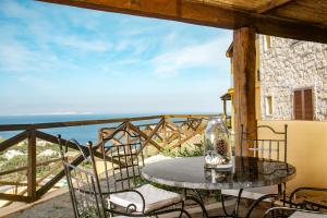 a table on a balcony with a view of the ocean at Punta Falcone Resort in Santa Teresa Gallura