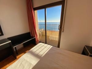 a bedroom with a bed and a view of the ocean at Mar Play in Sant Antoni de Calonge
