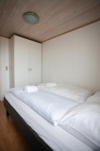 Un dormitorio con dos camas con sábanas blancas. en 2BR Apt / Central / Tórshavn, en Tórshavn