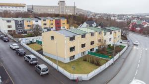a building with a green roof on the side of a street at 2BR Apt / Central / Tórshavn in Tórshavn