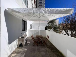 un patio con mesa y sombrilla en NorthWind Apartment, en Póvoa de Varzim