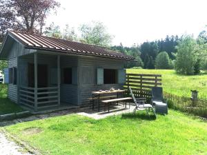 Cabaña pequeña con mesa y banco en un campo en AnNo - Wohlfühlen am Bachal en Neuschönau