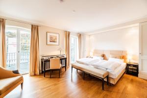 a white bedroom with a bed and a desk and a desk at Rheinhotel Schulz in Unkel