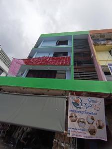 un edificio con una señal delante de él en OYO Home 90723 Green Leaf Guest Lodge Kk en Kota Kinabalu