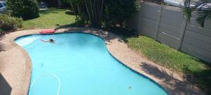 a man is in a swimming pool with a frisbee at 5 Oyster Crescent Villa Umhlanga in Durban