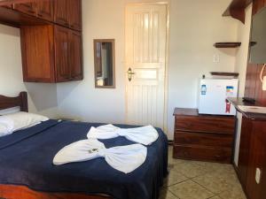 1 dormitorio con 1 cama con toallas en Pousada Paraiso do Sol en Saquarema