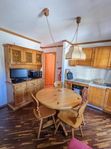 a kitchen with a wooden table and chairs at Residence Hotel Casa Metz in Santa Cristina Gherdëina