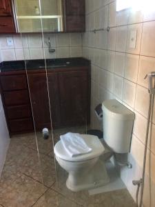 een badkamer met een wit toilet en een douche bij Pousada Paraiso do Sol in Saquarema