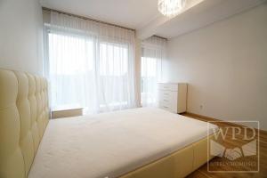 a bedroom with a bed and a large window at Modern Apartment-City Center-New Building-Garage in Wrocław