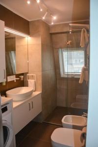 y baño con lavabo, aseo y ducha. en moderne Ferienwohnung, en Merano