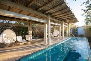 an outdoor swimming pool with a wooden pergola and a swimming poolvisor at Kapama Karula in Kapama Private Game Reserve