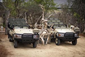 un par de vehículos de safari estacionados en un camino de tierra en Kapama River Lodge, en Kapama Private Game Reserve