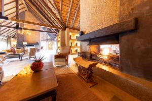 a living room with a large fireplace in a house at Kapama River Lodge in Kapama Private Game Reserve