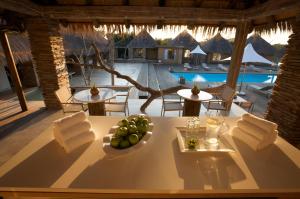 a table with a bowl of fruit on it with a pool at Kapama River Lodge in Kapama Private Game Reserve