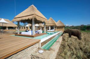 an elephant standing in front of a resort with a swimming pool at Kapama River Lodge in Kapama Private Game Reserve