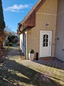 a brick house with a white door and a plant at Heideherz in Soltau
