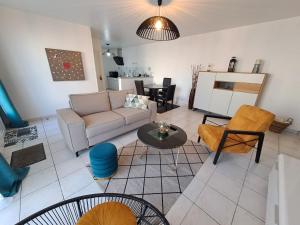 uma sala de estar com um sofá e uma mesa em - Maison Capucine- Proche centre d'affaire Chauray, Jardin, parking, WIFI et Netflix, idéal voyage d'affaire, familles, ou simple escapade em Chauray