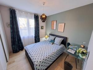 a small bedroom with a bed and a table at - Maison Capucine- Proche centre d'affaire Chauray, Jardin, parking, WIFI et Netflix, idéal voyage d'affaire, familles, ou simple escapade in Chauray
