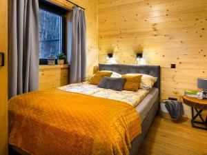 ein Schlafzimmer mit einem Bett in einer Holzwand in der Unterkunft DOMKI POD ZIELONYM WZGÓRZEM 2 in Kudowa-Zdrój
