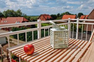 ein Apfel auf einer Holzbank auf einem Balkon in der Unterkunft Apfelhof Wegener in Jork