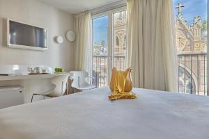 um quarto de hotel com uma cama com uma grande janela em Hotel Maciá Granada Five Senses Rooms & Suites em Granada