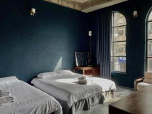 Un dormitorio con dos camas y una pared azul. en 太古Taikoo home, en Tainan 67 fotos más