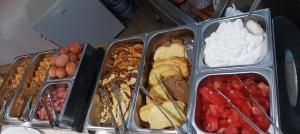 um grupo de recipientes cheios com diferentes tipos de alimentos em Vanta Studio em Limenas