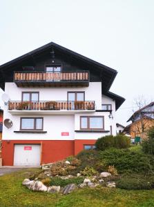 Maison blanche et orange avec balcon dans l'établissement Untersee24 - Lake Hallstatt Apartment, à Bad Goisern