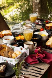 a table topped with plates of food and drinks at DOM Hotel Boutique in Campos do Jordão