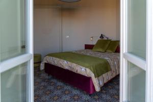 a bedroom with a bed in a room with a window at Madamin 