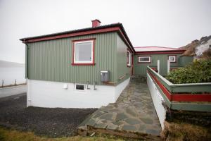 um edifício verde e branco com um caminho ao lado em Charming 2BR apartment, sea view em Tórshavn