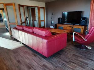 uma sala de estar com um sofá vermelho e uma televisão em Homestay, millions dollars view at Mount Pleasant em Christchurch