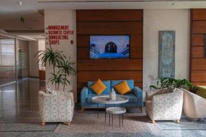 a lobby with a blue couch and two chairs at La Casa Hotel Amman by FHM in Amman