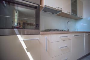 a kitchen with white cabinets and a sink at Apartman Marenic in Cres